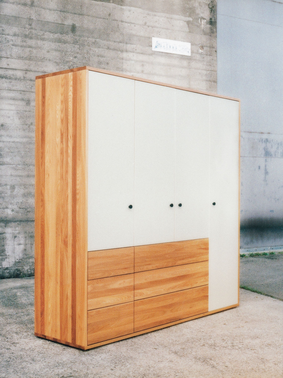 Massvholzschrank in Ulme mit farbig lackierten Glastüren und Holzschubladen