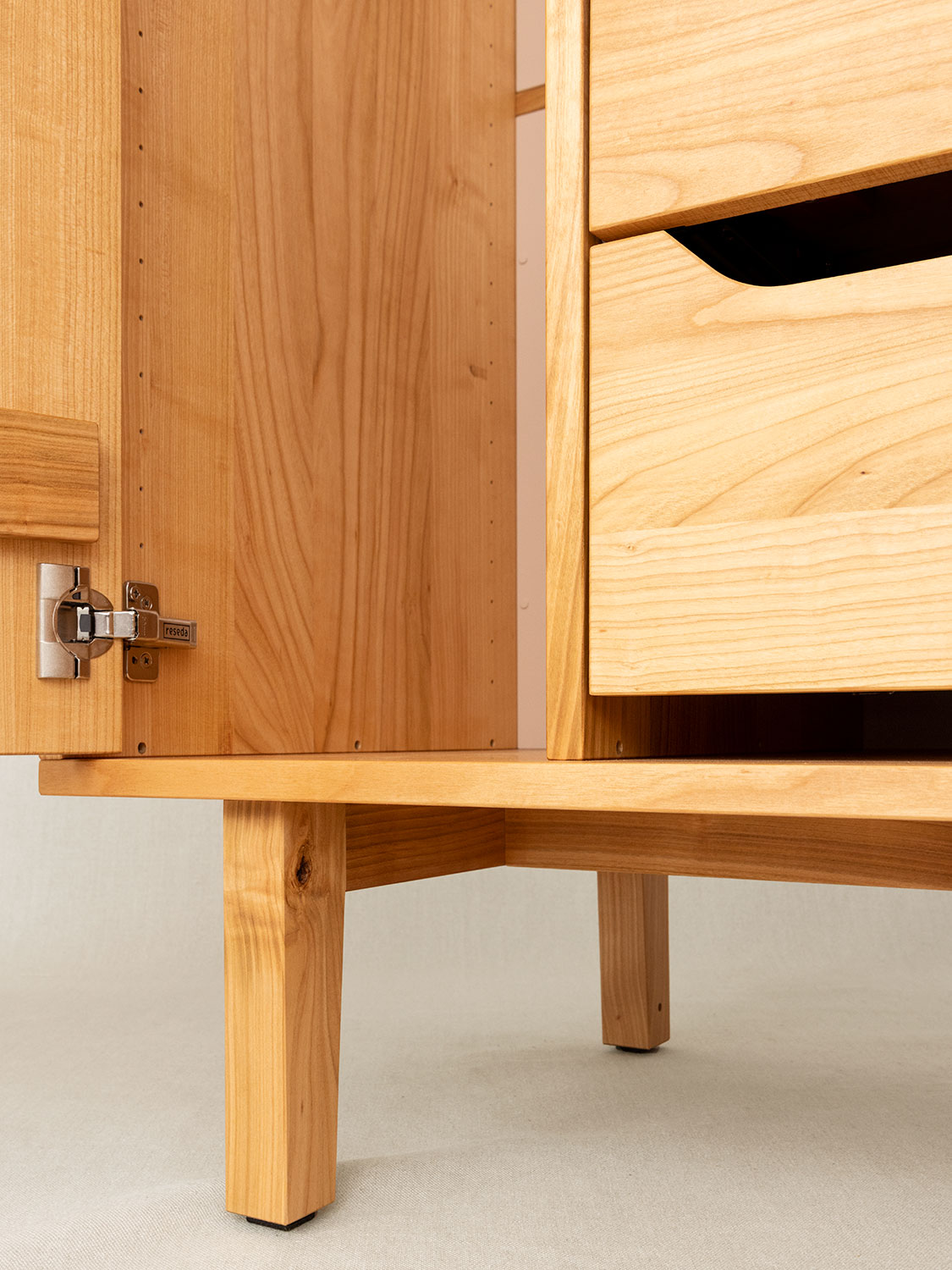 Massivholzschrank auf F&uuml;ssen in Kirschbaum, Detail Fussunterkonstruktion