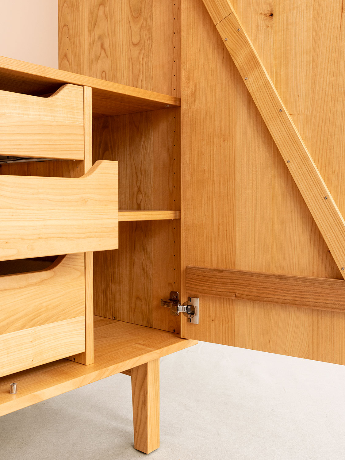 Massivholzschrank mit F&uuml;ssen in Kirschbaum, Detailaufnahme von Innenschubladen, T&uuml;r und Fuss