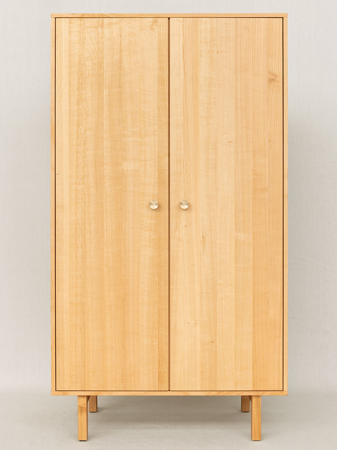 Massivholzschrank auf Füssen in Kirschbaum, 105 × 189 × 52 cm mit zwei Türen und Messinggriffen