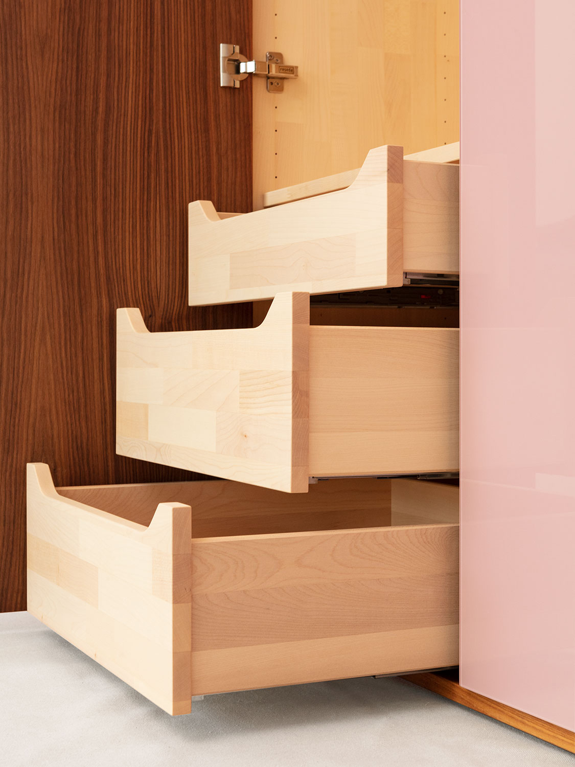Massivholzschrank "Sfera" aus Nussbaum massiv mit Türen aus farbig lackiertem Glas. Innenschulbladen aus keilgezinktem Ahorn.