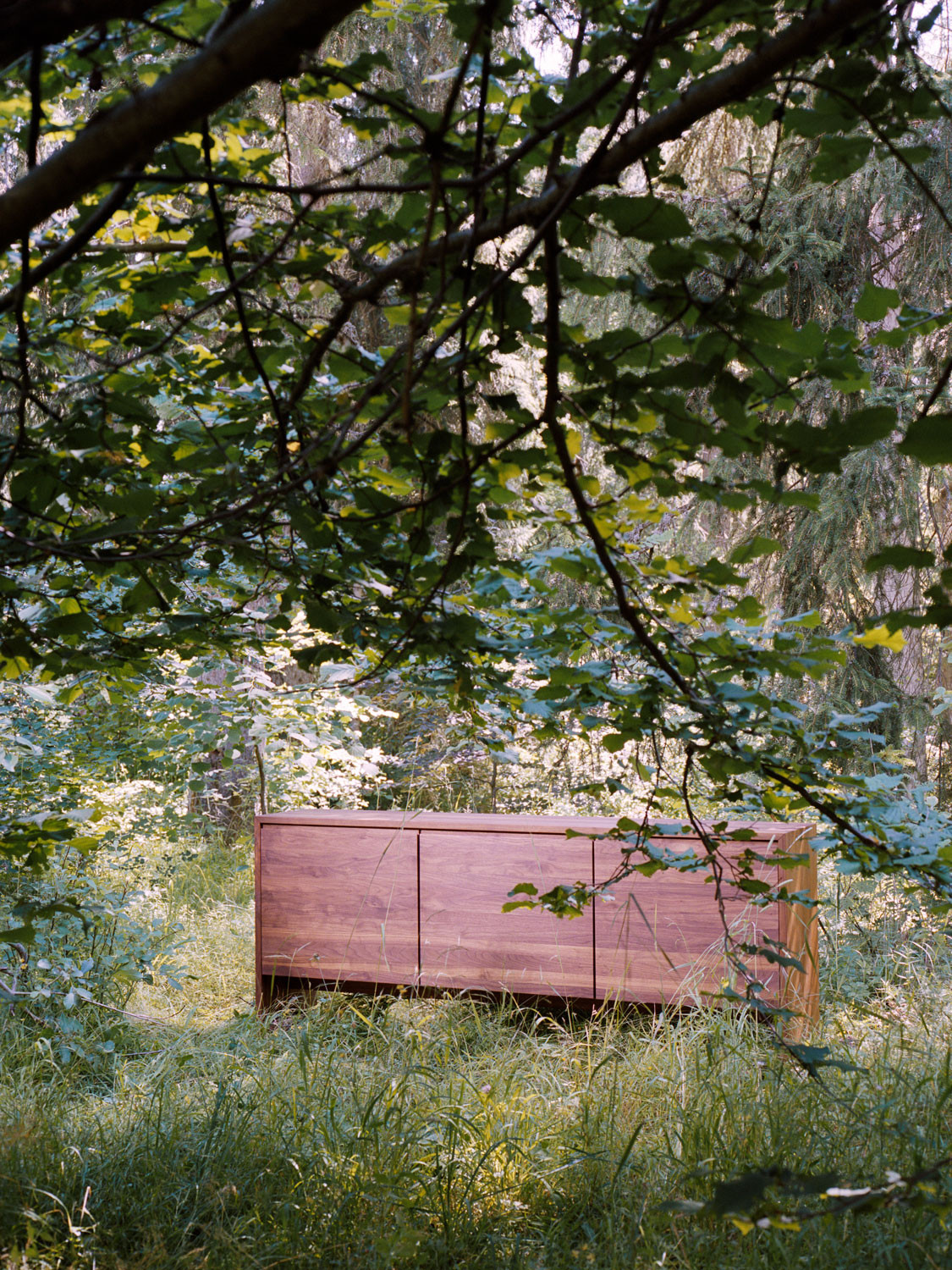 Massivholzsideboard aus Nussbaum auf Wangen und mit drei Türchen mit durchgehendem Holzbild.