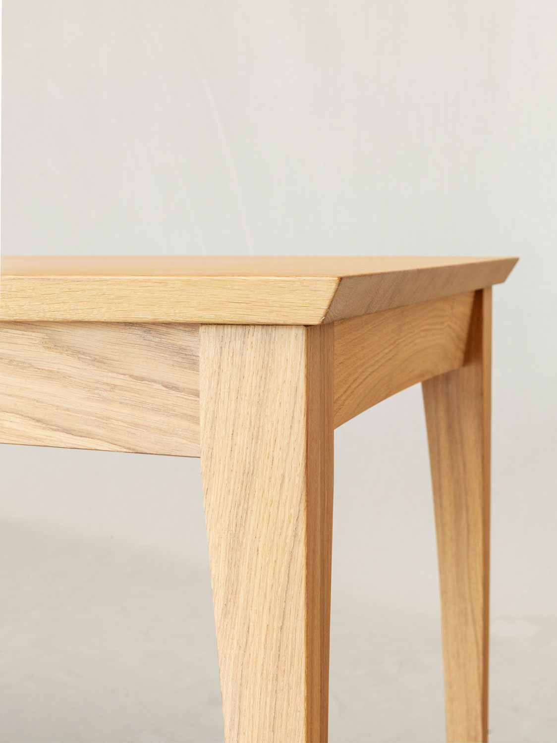 Esstisch Filago, Eckdetail mit geschwungenem Bein und Zarge, Eiche massiv weissge&ouml;lt