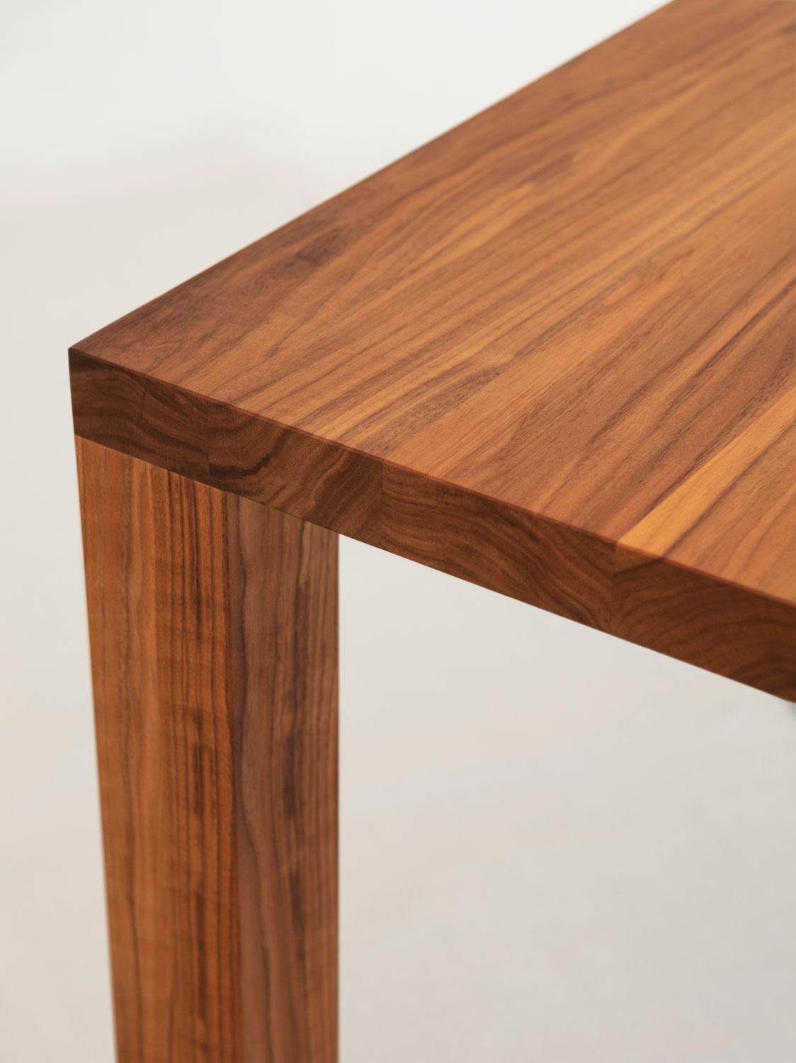 Esstisch Redu in Nussbaum massiv, ab 180 cm Länge beträgt die Plattenstärke 4 und das Beindicke 8 cm.